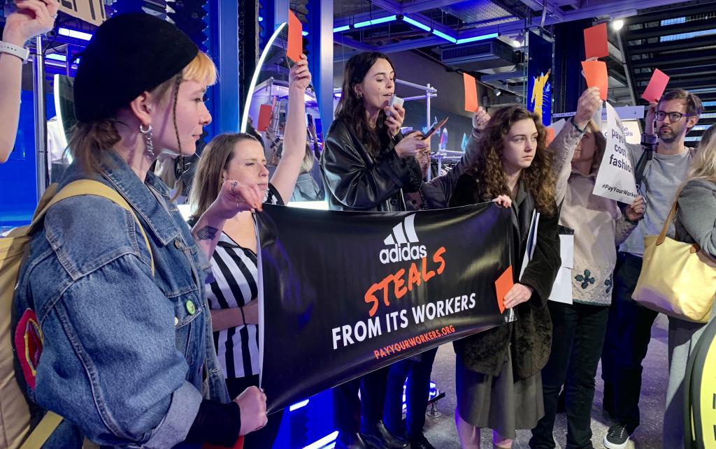 UK activists from War on Want and Labour Behind the Label demonstrate in solidarity with garment workers facing wage theft in Addidas’ supply chains. London, November 2022.