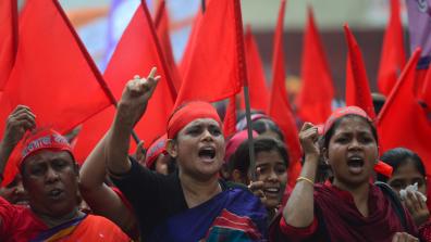 Women protest at a May Day Demonstration, with red headbands and flags. Dhaka, Bangladesh. Credit: MUNIR UZ ZAMAN / AFP / Getty Images