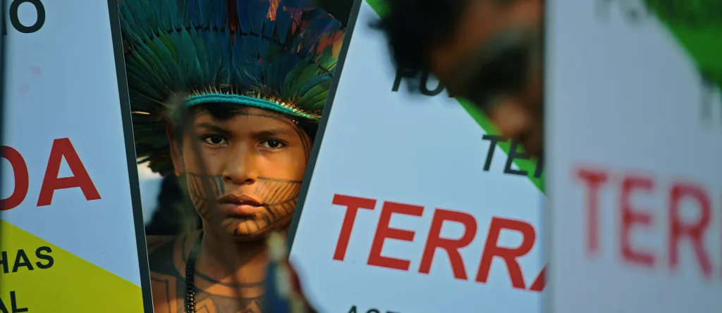 Indigenous Brazilian boy looks at the camera at a protest