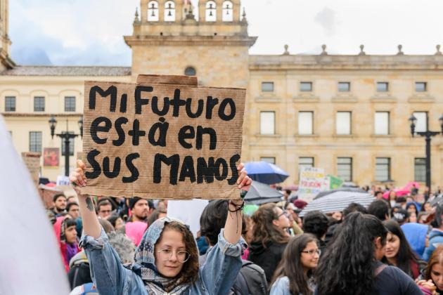 Protester at climate march holds up placard reading "Mi Futuro esta en sus manos" (My future is in your hands)