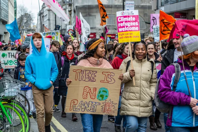 People protesting holding various placards with slogans on them.