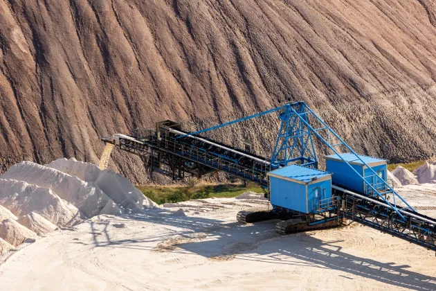 A photo showing a potash mine. A digger is stationed and appears to be working around the mine.
