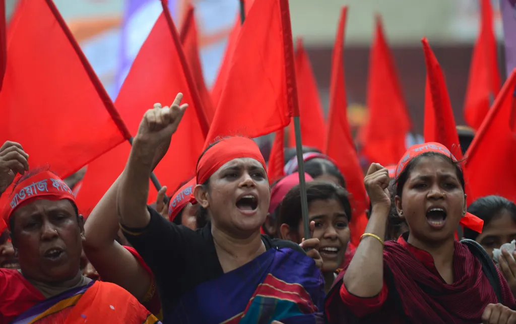 Women protest at a May Day Demonstration, with red headbands and flags. Dhaka, Bangladesh. Credit: MUNIR UZ ZAMAN / AFP / Getty Images