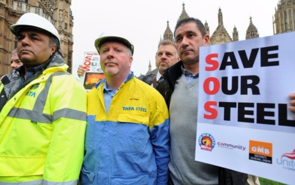 Protestors in workers' helmets and hi-vis hold a sign that reads Save Our Steel