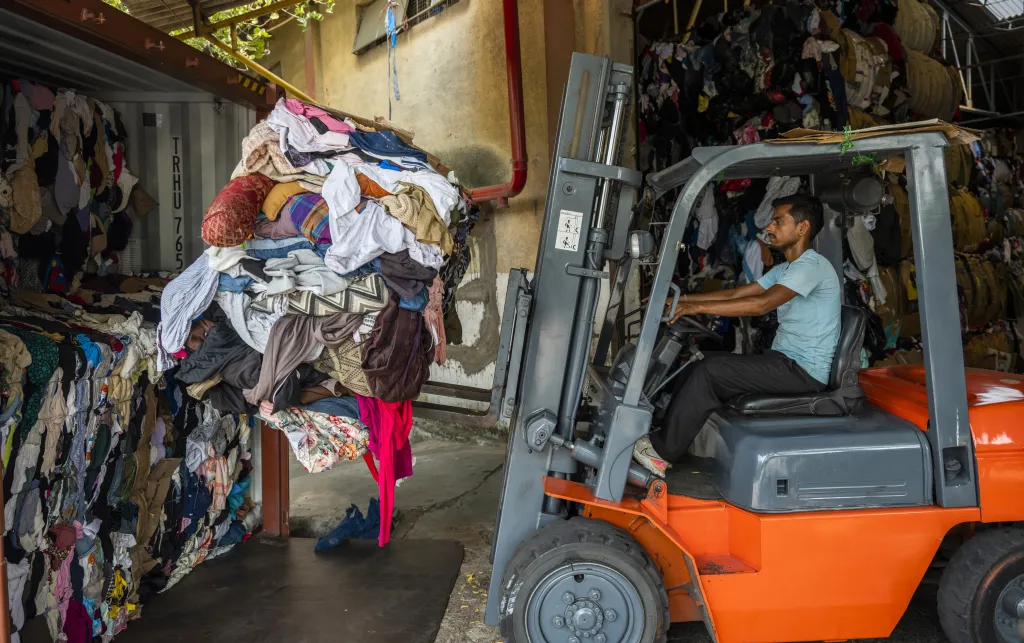 A forklift operator offloads bales of imported clothes at a facility in Kandla, India, September 2022.