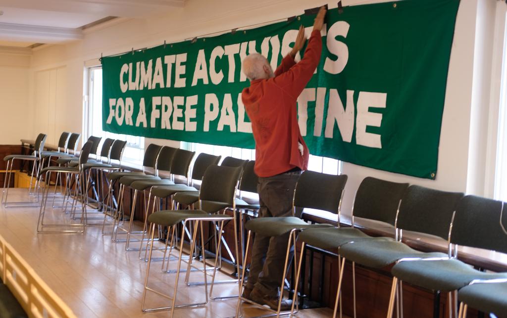 Green banner which has 'Climate activists for a free Palestine' written across it in white writing.
