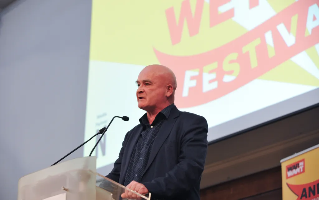 Mick Lynch standing at the lectern in the middle of a speech.