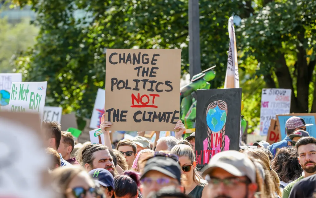 People holding banners including one which reads: 'Change the politics not the climate!'