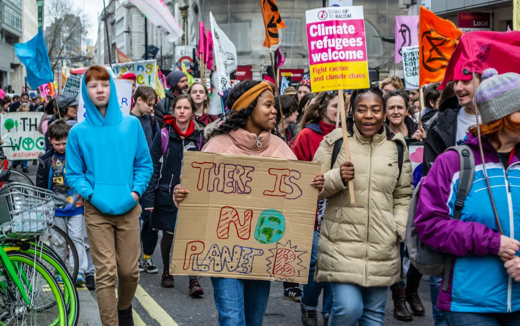 People protesting holding various placards with slogans on them.