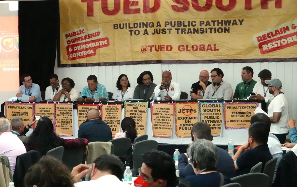People sitting on a panel looking like they are talking to an audience.