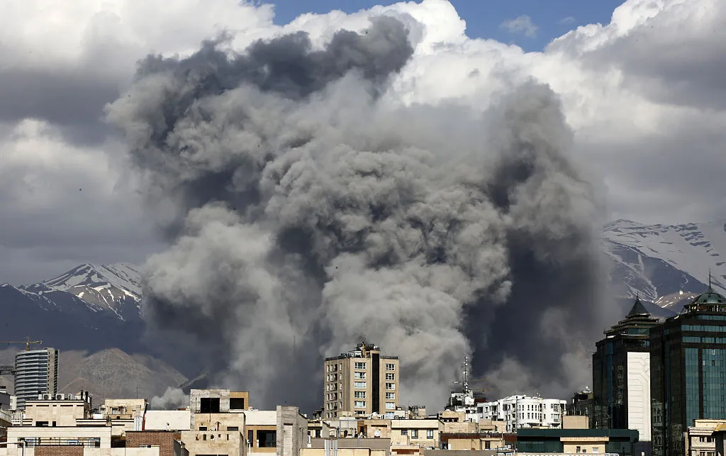 Buildings with grey smoke clouds behind