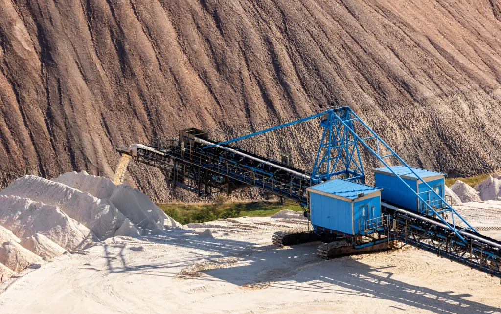 A photo showing a potash mine. A digger is stationed and appears to be working around the mine.