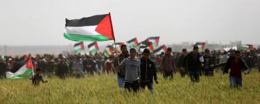 Palestinians with flags at the Great Return March in Gaza. Credit: Ashraf Amra / APA Images