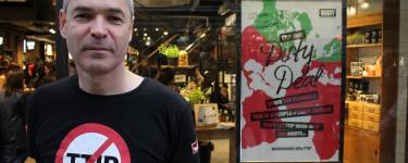 Executive Director John Hilary, wearing a No TTIP t shirt, stands in front of a Lush store that has an advert in the window reading: "Vivienne Westwood; TTIP that dirty deal down the plughole; This is a people-power shower; don't let TTIP wash away our rights....; waronwant.org/ttip"
