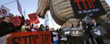 A demonstration to 'Stop TTIP', with a giant inflatable wooden horse and a banner on it that reads "TTIP: The Trojan Treaty".