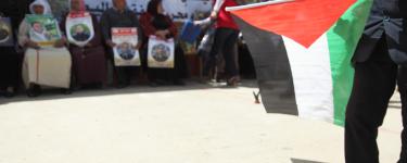 Palestinian prisoner solidarity demonstration with a Palestinian flag in the foreground. Credit: War on Want/Rich Wiles