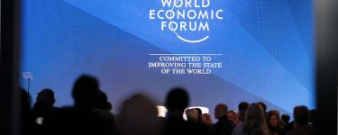 A screen at DAVOS reads: "World Economic Forum – Committed to improving the state of the world". Photo: U.S. Embassy Bern/ Eric Bridiers