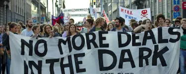 Protest in Brussels against the TTIP and CETA free trade agreements. Protesters hold a banner that says "No more deals in the dark. TTIP game over." Photo: M0tty