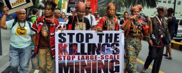 Kalikasan members march with signs saying "Mining plunder kills!" and "Stop the killings, stop large-scale mining". Photo: Kalikasan People's Network for the Environment.