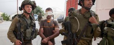 Israeli soldiers arrest a Palestinian man. Photo: Majdi Mohammed/ AP/ Shutterstock