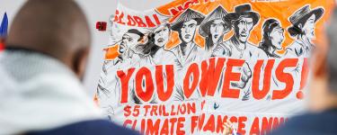 An orange and white banner that has the text "You owe us!" written on it,