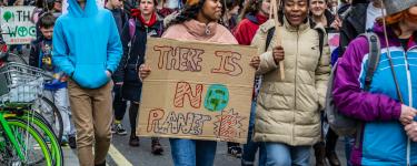 People protesting holding various placards with slogans on them.