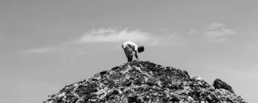 Photo of a person atop a mountain of clothes