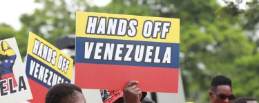 Protestor holds banner saying 'HANDS OFF VENEZUELA'.