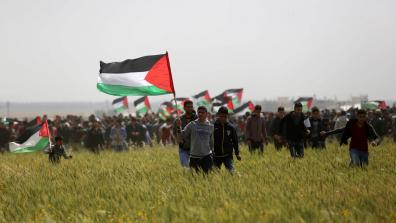 Palestinians with flags at the Great Return March in Gaza. Credit: Ashraf Amra / APA Images