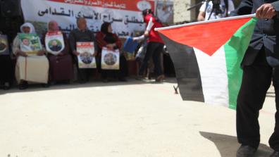 Palestinian prisoner solidarity demonstration with a Palestinian flag in the foreground. Credit: War on Want/Rich Wiles