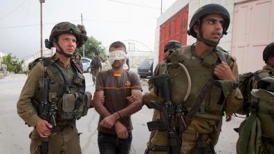 Israeli soldiers arrest a Palestinian man. Photo: Majdi Mohammed/ AP/ Shutterstock