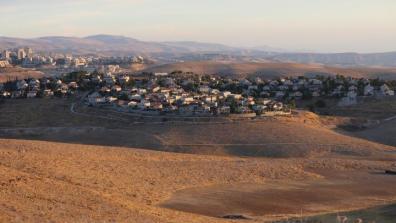 An Israeli settlement, buildings in the distance across the desert.