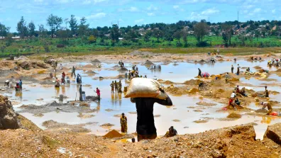 A photo showing a muddy field in which people are working.