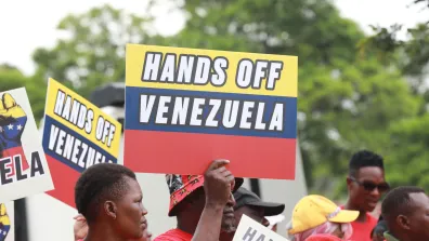 Protestor holds banner saying 'HANDS OFF VENEZUELA'.