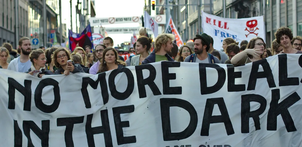Protest in Brussels against the TTIP and CETA free trade agreements. Protesters hold a banner that says "No more deals in the dark. TTIP game over." Photo: M0tty